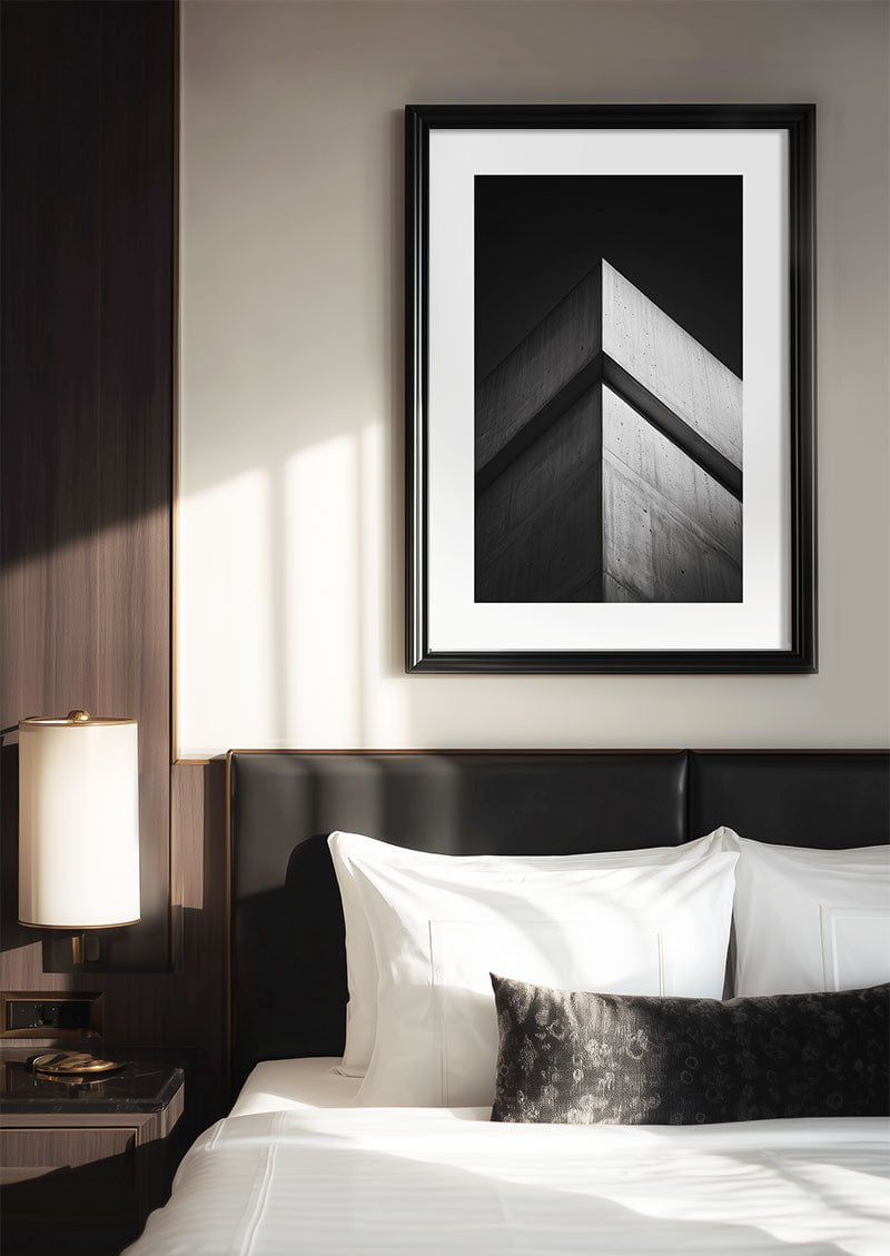 Affiche photographie en noir et blanc d'un angle architectural encadrée au dessus d'un lit