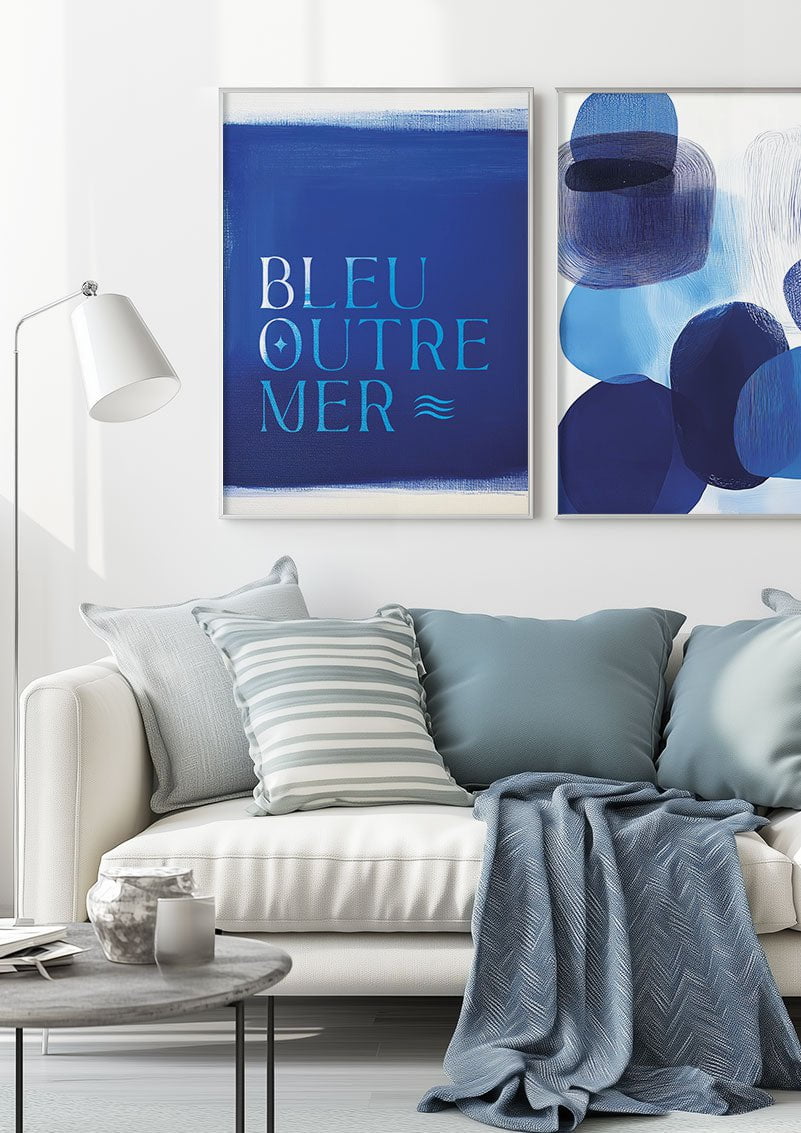 Duo d'affiches mer et plage bleu marine encadrées au dessus d'un canapé