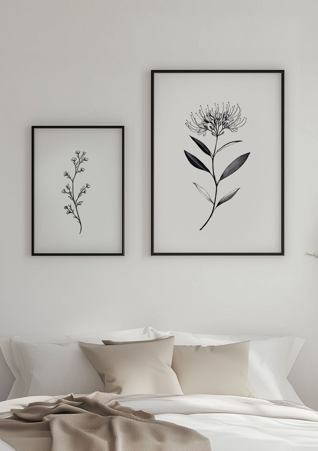 Deux affiches de fleurs en noir et blanc encadrées sur le mur d'une chambre aux tons neutres.