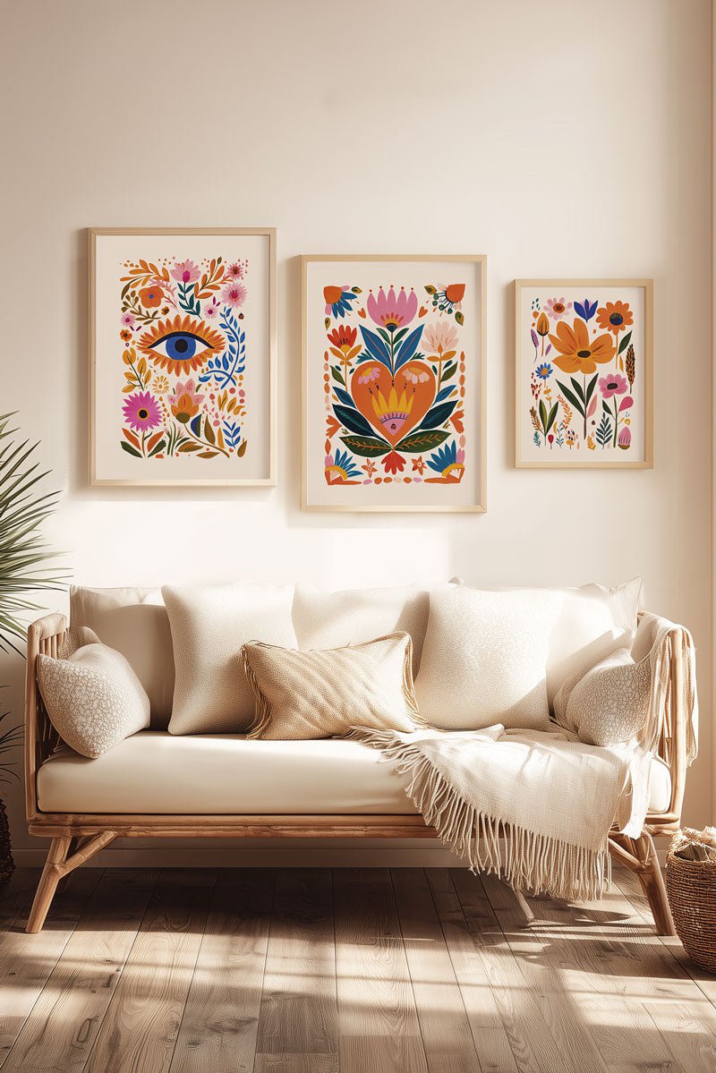 Trio d'affiche folk art œil coeur et fleurs, encadrées au dessus d'un canapé beige