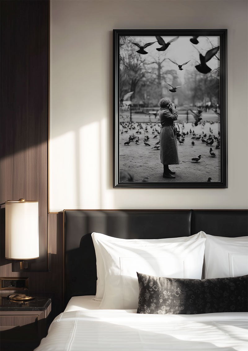 poster photo noir et blanc d'une dame et des pigeons encadrée au dessus d'un lit
