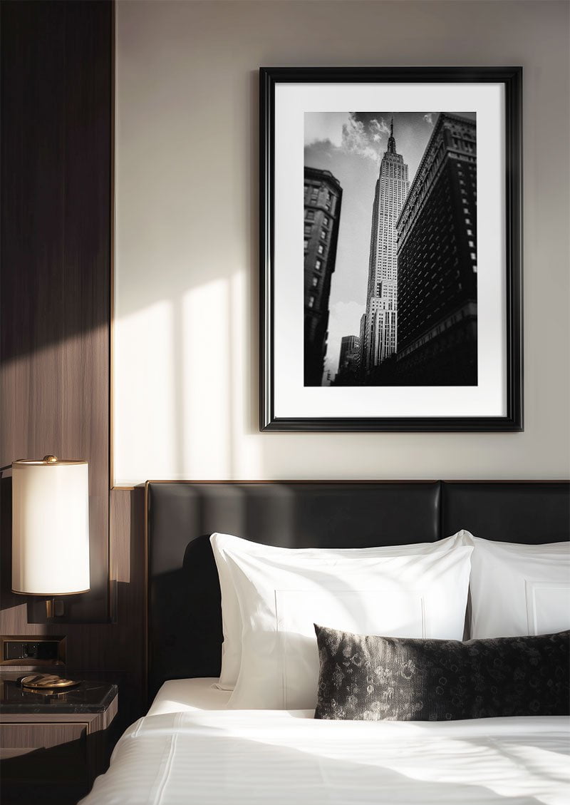 Poster photo noir et blanc de l'empire state building encadrée au dessus d'un lit