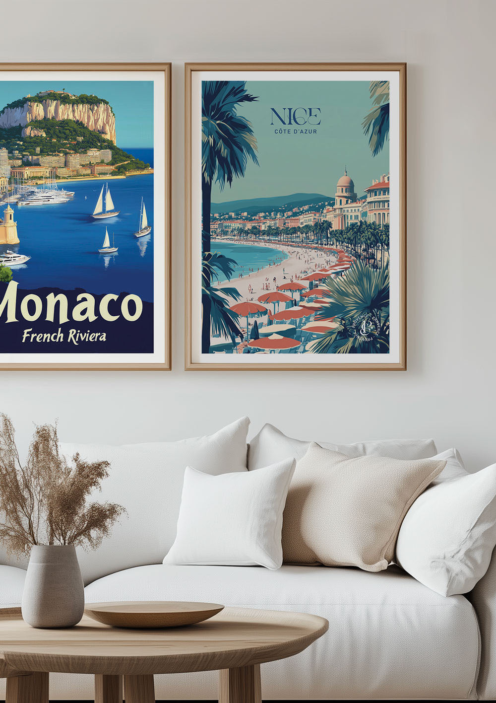 Duo d'affiches de villes rétro encadrées au dessus d'un canapé blanc.