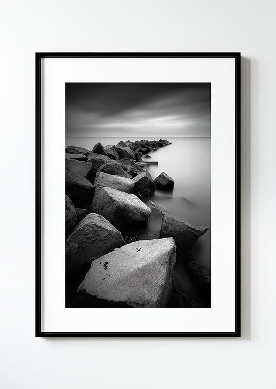 Photographie noir et blanc d'une digue avec un paysage brumeux, dans un cadre noir