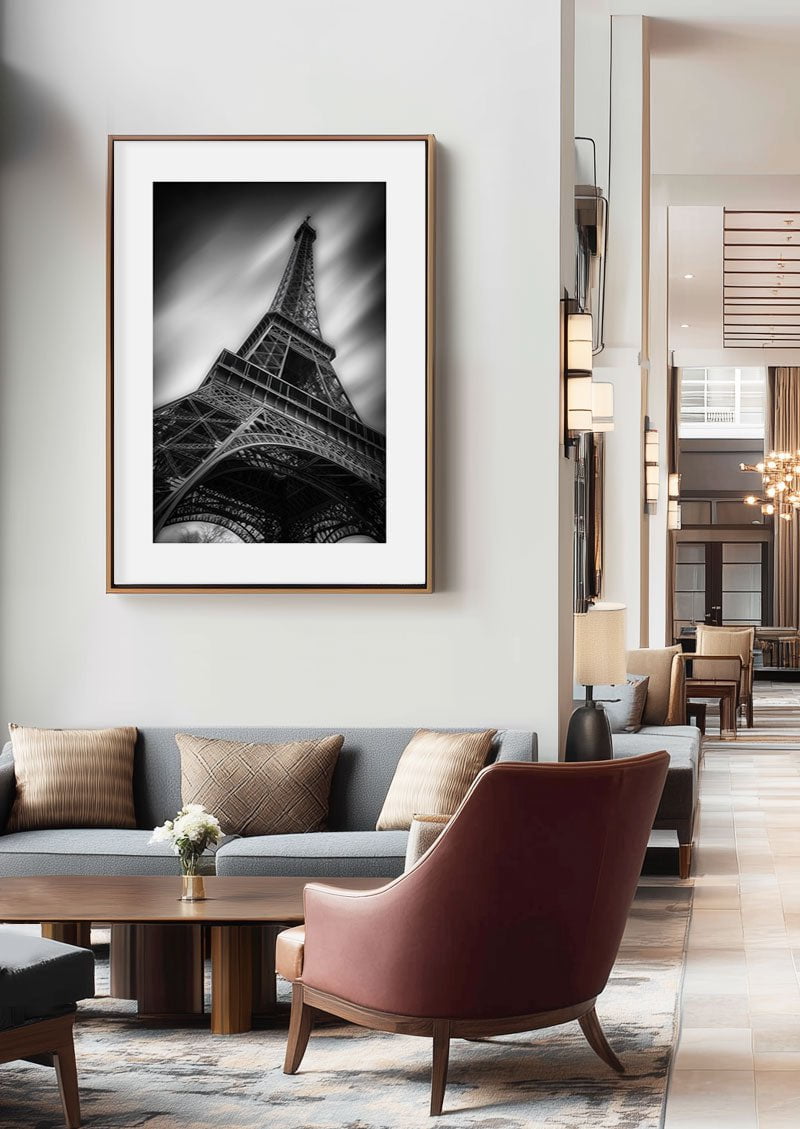 Poster déco noir et blanc de la tour eiffel dans un cadre en bois au dessus d'un canapé