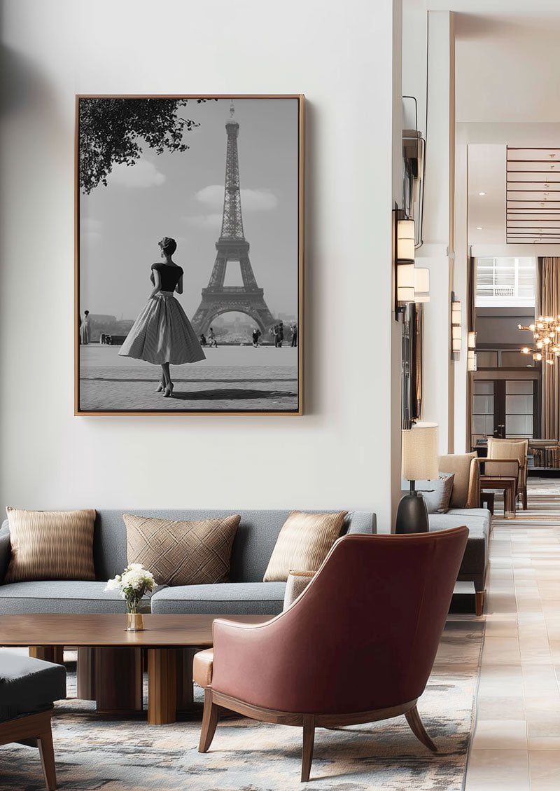Poster déco d'une femme devant la tour eiffel mit en situation au dessus d'un canapé dans un hotel
