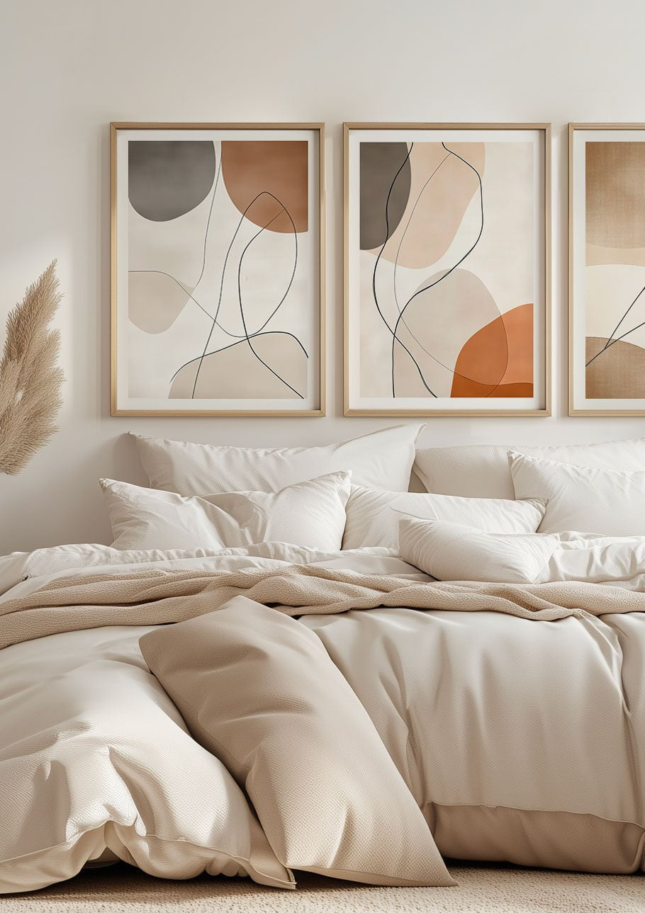 Deux affiches murales minimalistes et contemporaines, encadrées au-dessus d'un lit.