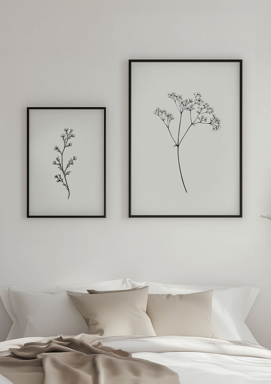 Deux affiches branches de fleurs encadrées sur un mur blanc.