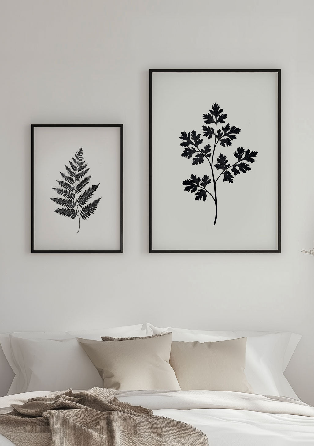 Deux affiches florales en noir sur blanc encadrées et mises en valeur sur un mur.