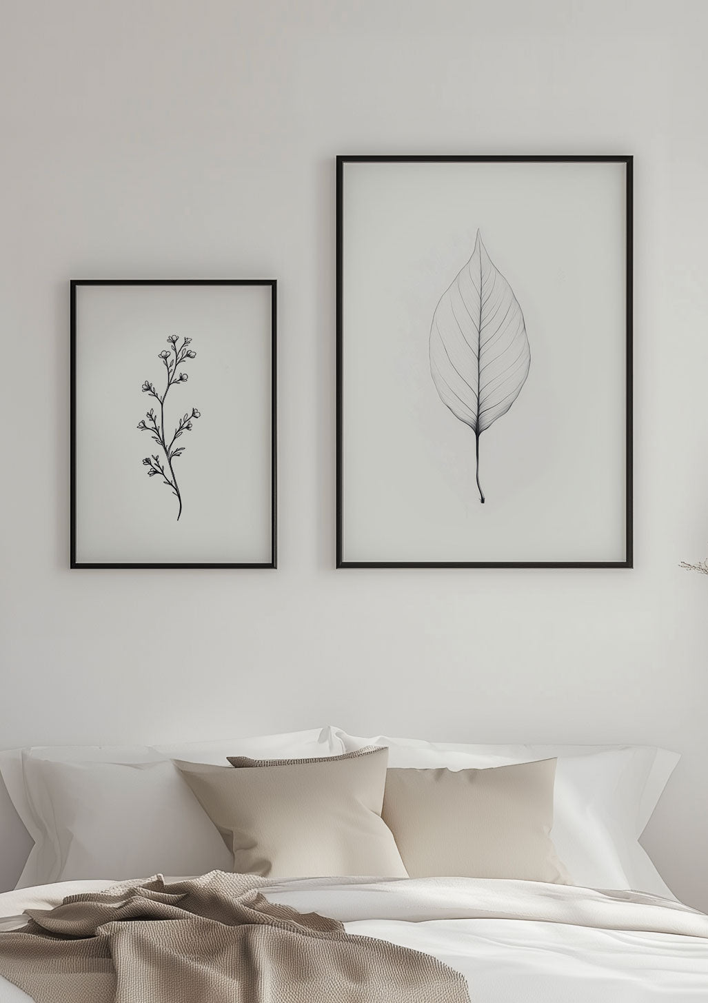 Duo d'affiches florales encadrées sur un mur au dessus d'un lit.