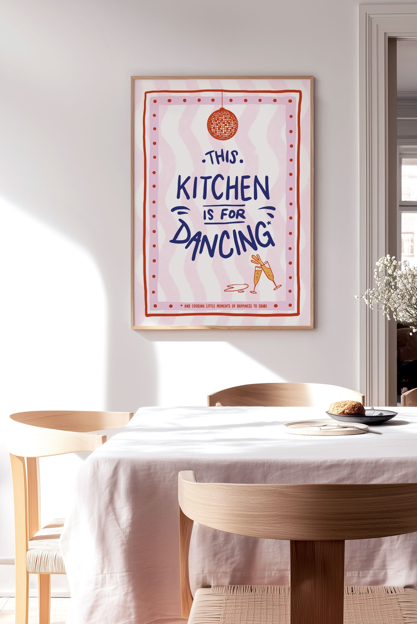 Affiche illustration pop "this kitchen" sur fond rose ondulé encadrée sur le mur d'une cuisine