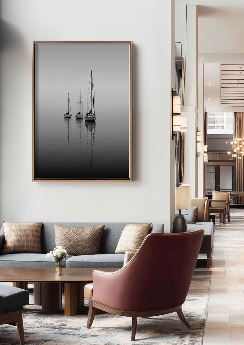 Poster photo noir et blanc de trois voiliers sur l'eau, encadrée dans un hall d'hotel