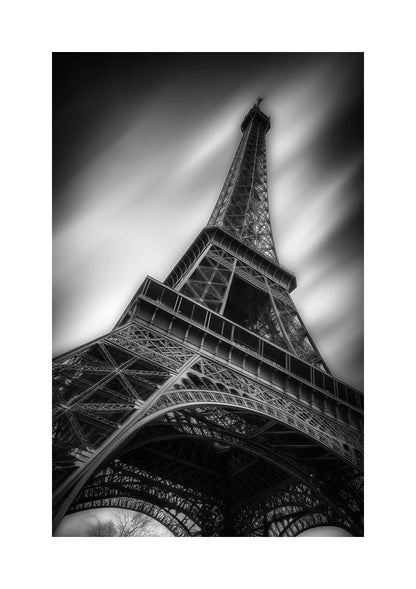 Affiche photographie noir et blanc de la tour eiffel vue d'en bas, avec un fond flou et bordure blanche