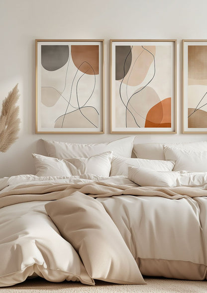 Deux affiches murales minimalistes et contemporaines, encadrées au-dessus d'un lit.