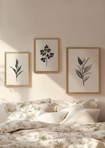 Trio d'affiche fleurs en noir et blanc, encadrée sur un mur au dessus d'un lit.
