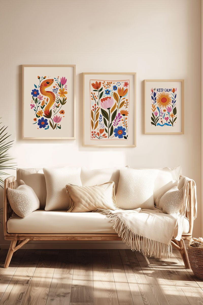 Trio d'affiche folk art serpent, fleurs, et soleil encadrées au dessus d'un canapé